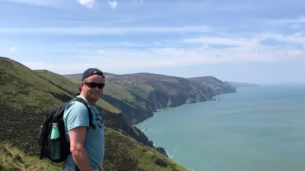 A man standing at the top of the cliffs on the Haddons Mouth Footpath