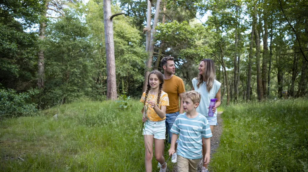 Young family on holiday walking through North Devon Woodland