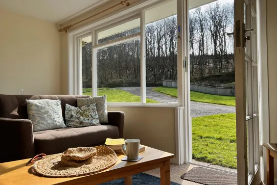 A view of the lawn from the windows in the lounge area of Camellia Cottage at Spreacombe Holiday Cottages