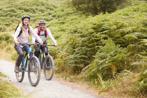 A couple mountain biking down a country lane