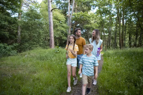 Young family on holiday walking through North Devon Woodland