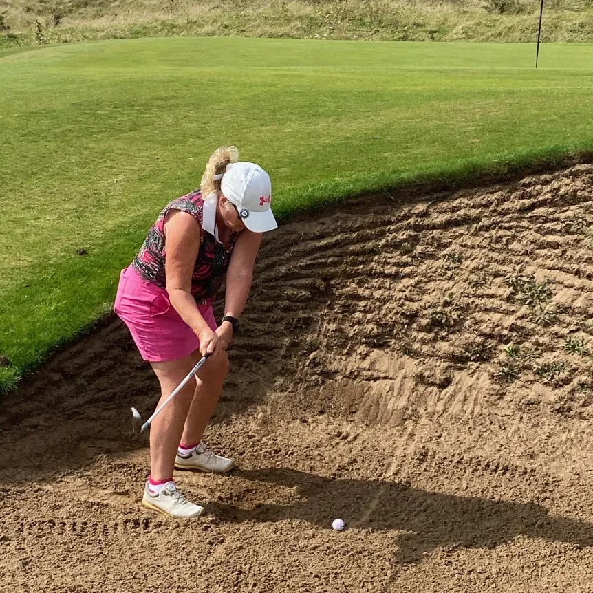 Golfer hitting out of a steep bunker at Saunton Sands golf course