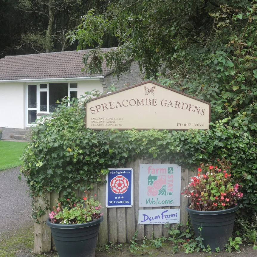 The entrance sign for Spreacombe Holiday Cottages with Azalea Cottage in the background