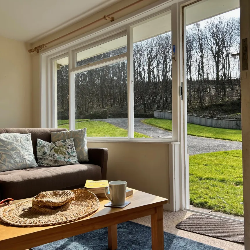 A view of the lawn from the windows in the lounge area of Camellia Cottage at Spreacombe Holiday Cottages
