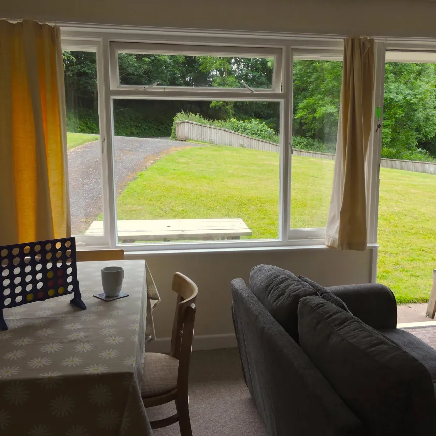 A view from the lounge diner in Clematis Cottage over the lawns at Spreacombe Holiday Cottages
