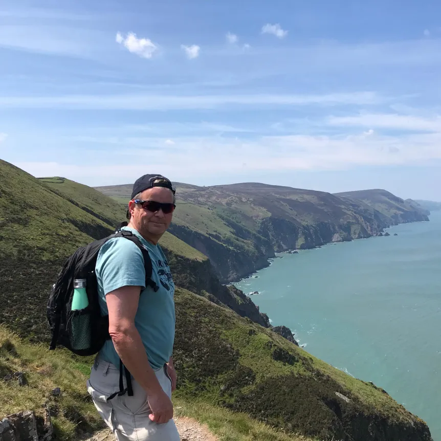 A man standing at the top of the cliffs on the Haddons Mouth Footpath