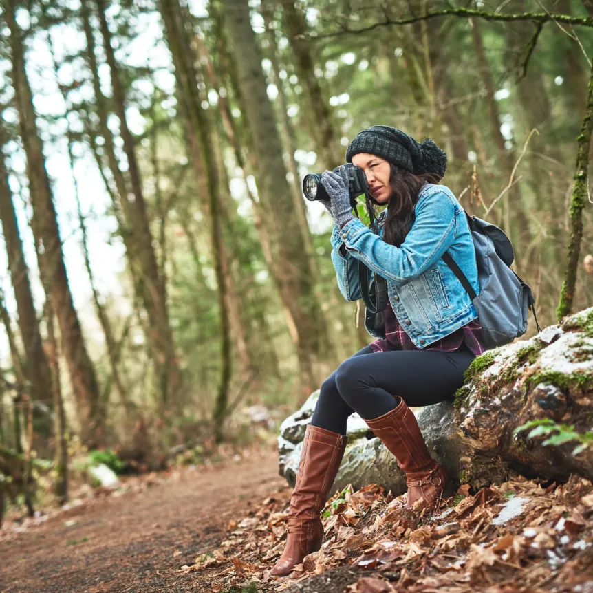 Shot of a young woman taking a picture of birds in the outdoors