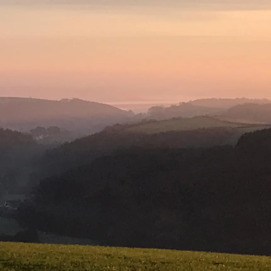 A view of the surrounding countryside at Spreacombe Holiday Cottages at sunset