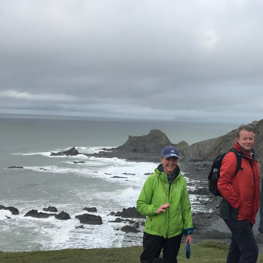 Couple standing on cliff path in rain