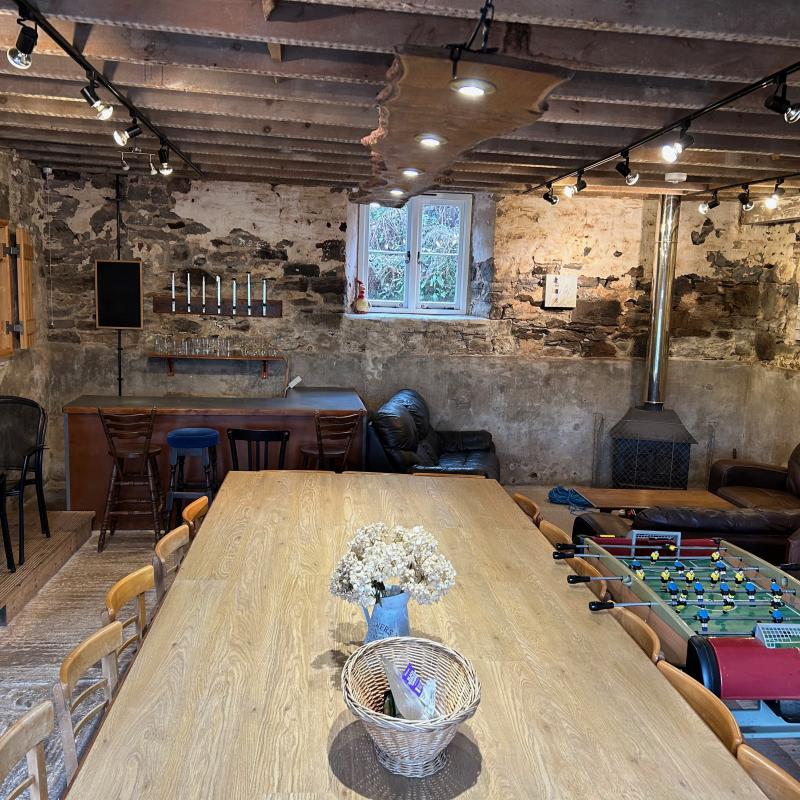 The activity room, called the old barn showing the large dining table with wood burner in the distance