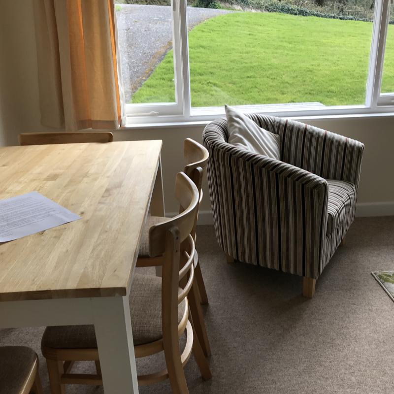 Dining area in Clematis Dining table and tub chair by window