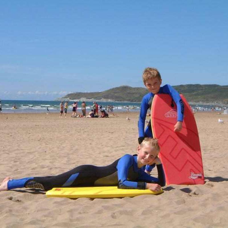 2 boys with body boards on sandy Woolacombe Beach